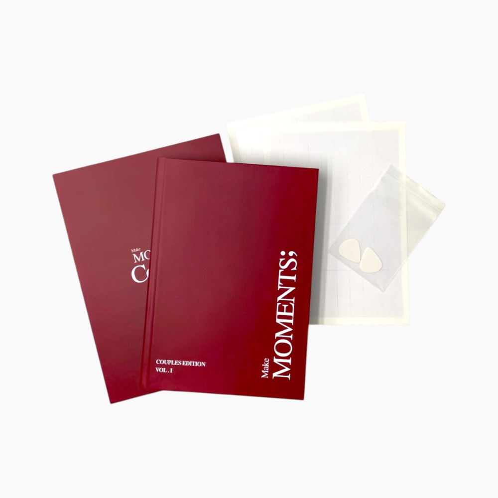 Book titled 'Make Moments Couples Edition Volume 1' with box, scratch tool and double sided tape on a white background